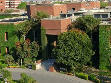 picture of LUMS academic block's red brick building covered with vines 