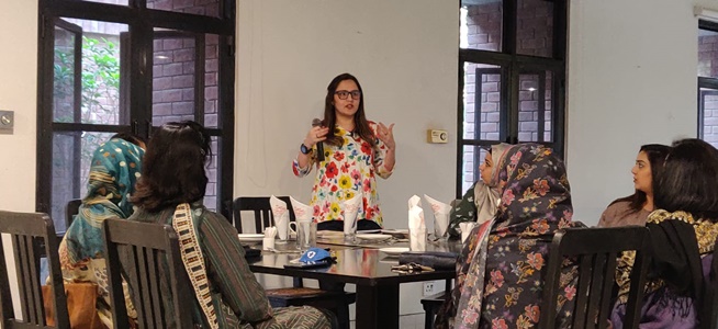 Aymen wearing a floral shirt speaking to attendees 